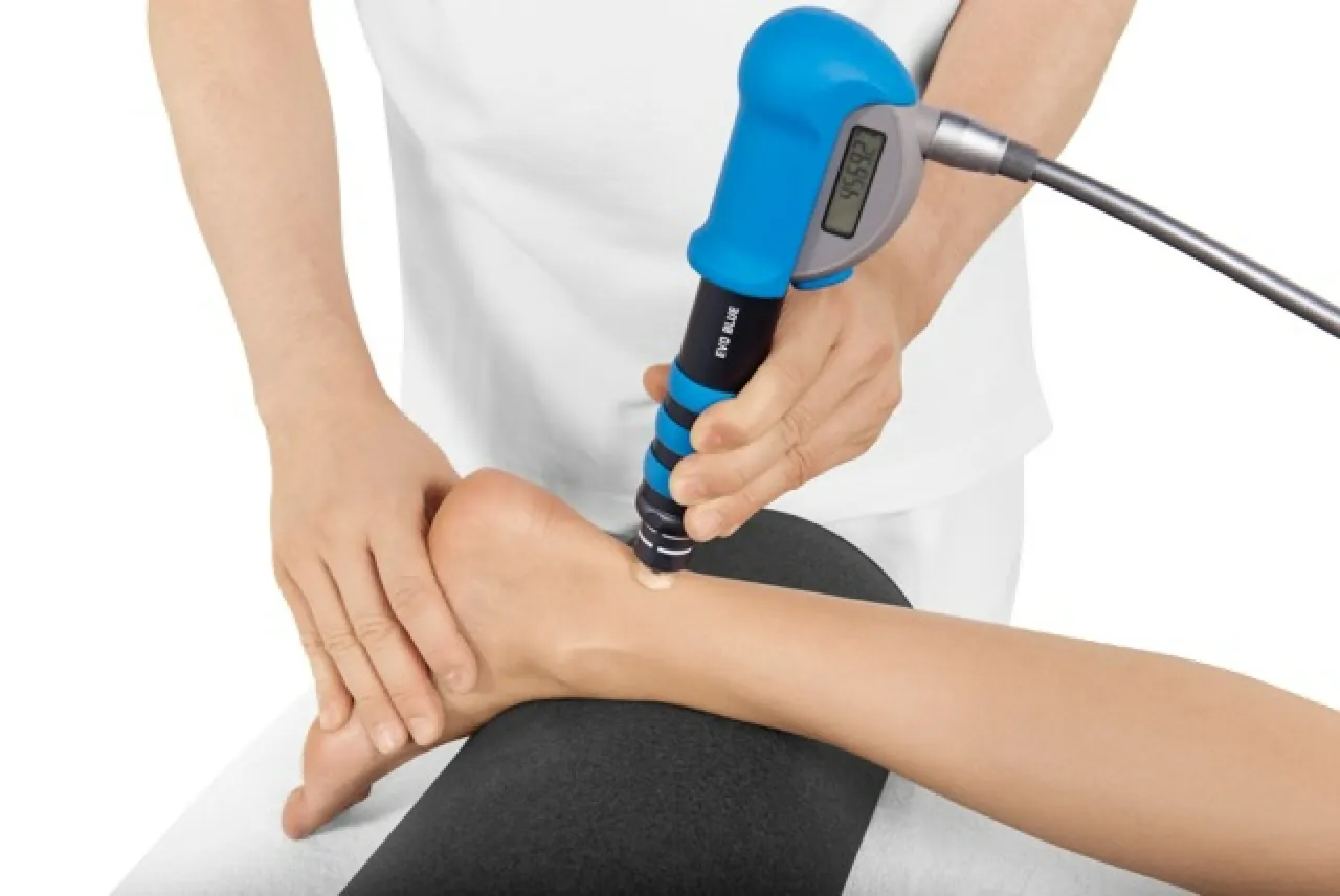 Acoustic wave therapy handpiece applied to a patient's ankle